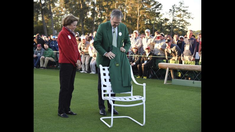 Billy Payne, the chairman of the Augusta National Golf Club, places Arnold Palmer's jacket on a chair at the honorary start of the tournament. Palmer's wife, Kathleen, looks on. Palmer, a four-time Masters winner, <a href="index.php?page=&url=http%3A%2F%2Fwww.cnn.com%2F2016%2F09%2F25%2Fus%2Farnold-palmer-death%2Findex.html" target="_blank">died in September</a> at the age of 87.