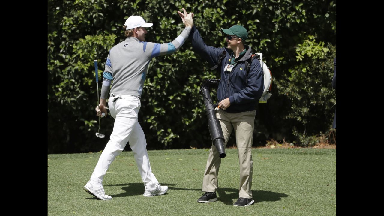 Brandt Snedeker, left, high-fives a crew member after making a putt on the fourth hole.