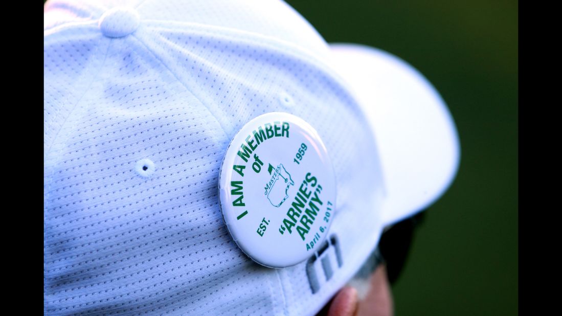 A fan wears a pin in honor of Arnold Palmer.