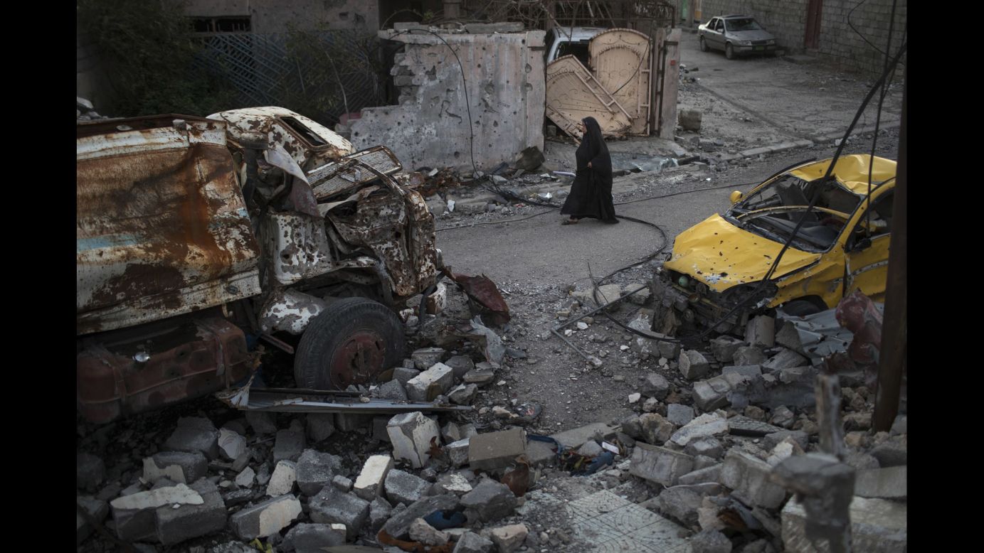 A woman walks past damaged vehicles in Mosul, Iraq, on Wednesday, April 5. Iraqi forces <a href="http://www.cnn.com/interactive/2017/03/world/mosul-iraq-cnnphotos/index.html" target="_blank">have been fighting ISIS militants</a> for control of the city.