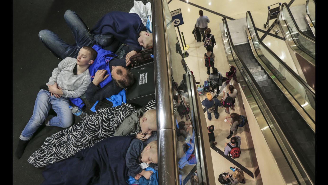 Stranded travelers rest at Atlanta's international airport on Thursday, April 6. Hundreds of flights were canceled because of severe thunderstorms in the area.