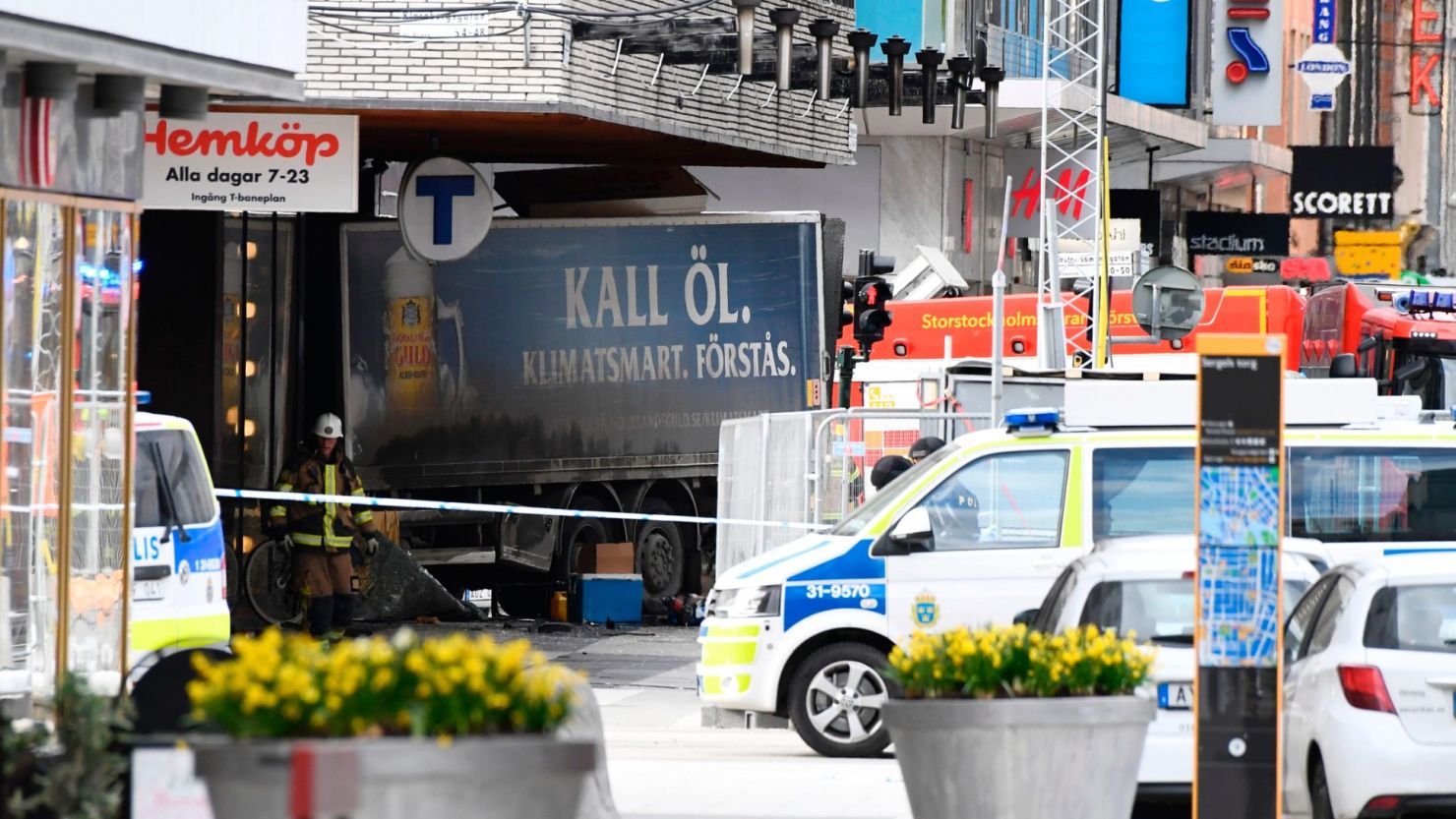 Emergency services work at the scene where a truck crashed into the Ahlens department store in central Stockholm on April 7. the truck hit pedestrians before it struck the store; four peole were killed, authorities said.