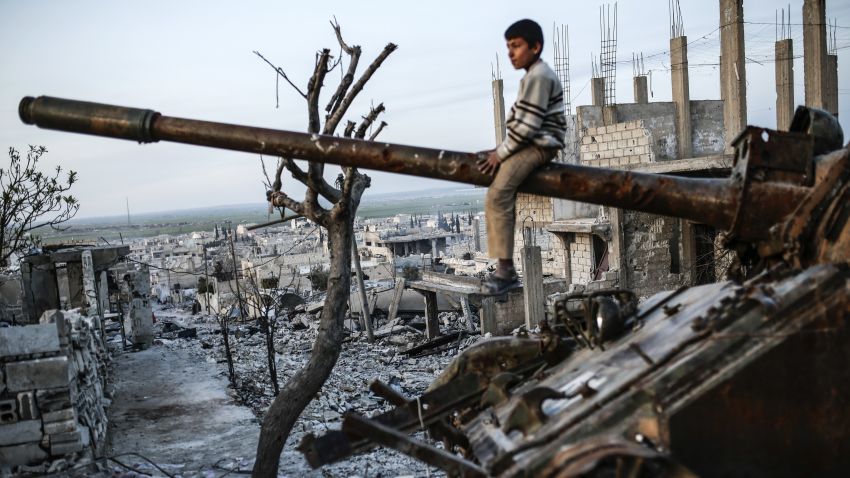 A Syrian Kurdish boy sits on a destroyed tank in the Syrian town of Kobane, also known as Ain al-Arab, on March 27, 2015. Islamic State (IS) fighters were driven out of Kobane on January 26 by Kurdish and allied forces. AFP PHOTO/YASIN AKGUL (Photo credit should read YASIN AKGUL/AFP/Getty Images)