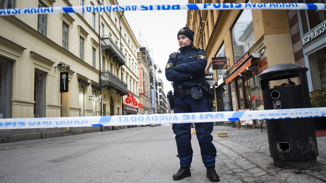 A police officer stands guard on April 8, 2017 at the site where a stolen truck was driven through a crowd and crashed into the Ahlens department store in central Stockholm the day before.