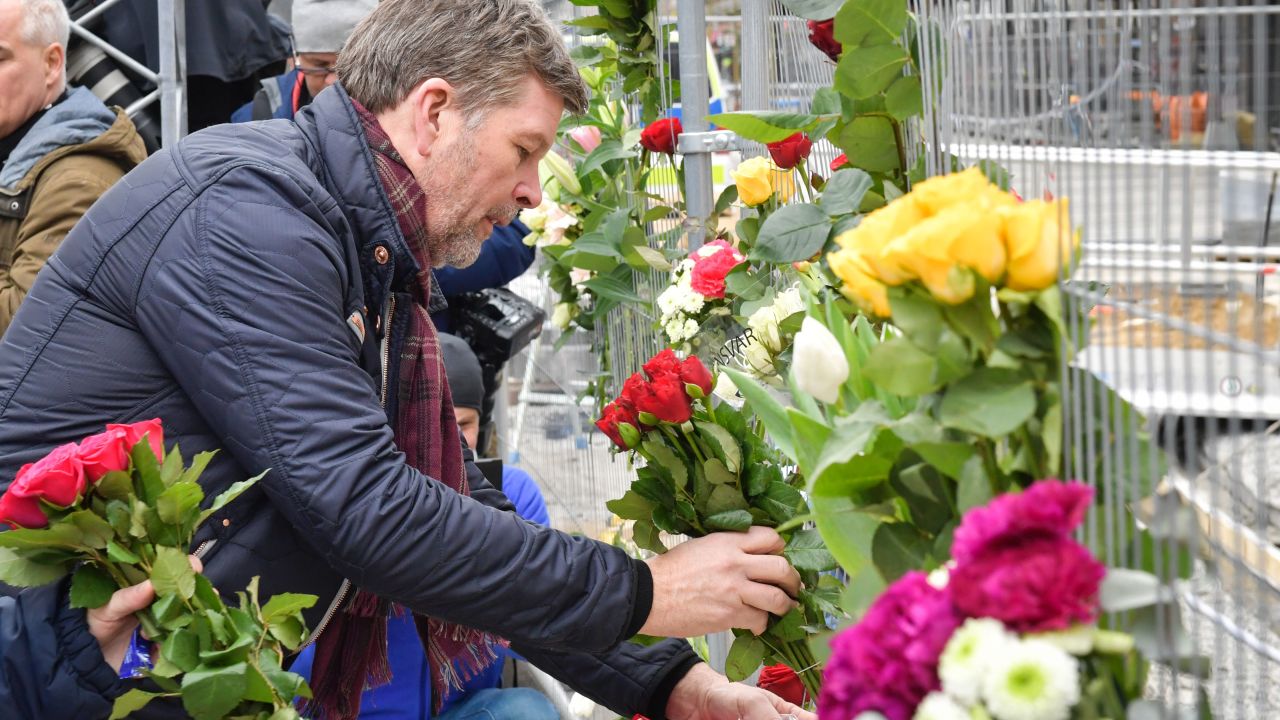 People lay flowers Saturday at the scene of a truck attack in central Stockholm.
