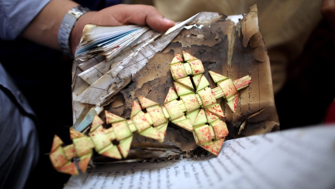 A member of the security forces carries a palm leaf at the scene of a bomb explosion inside Mar Girgis church in Tanta, Egypt.