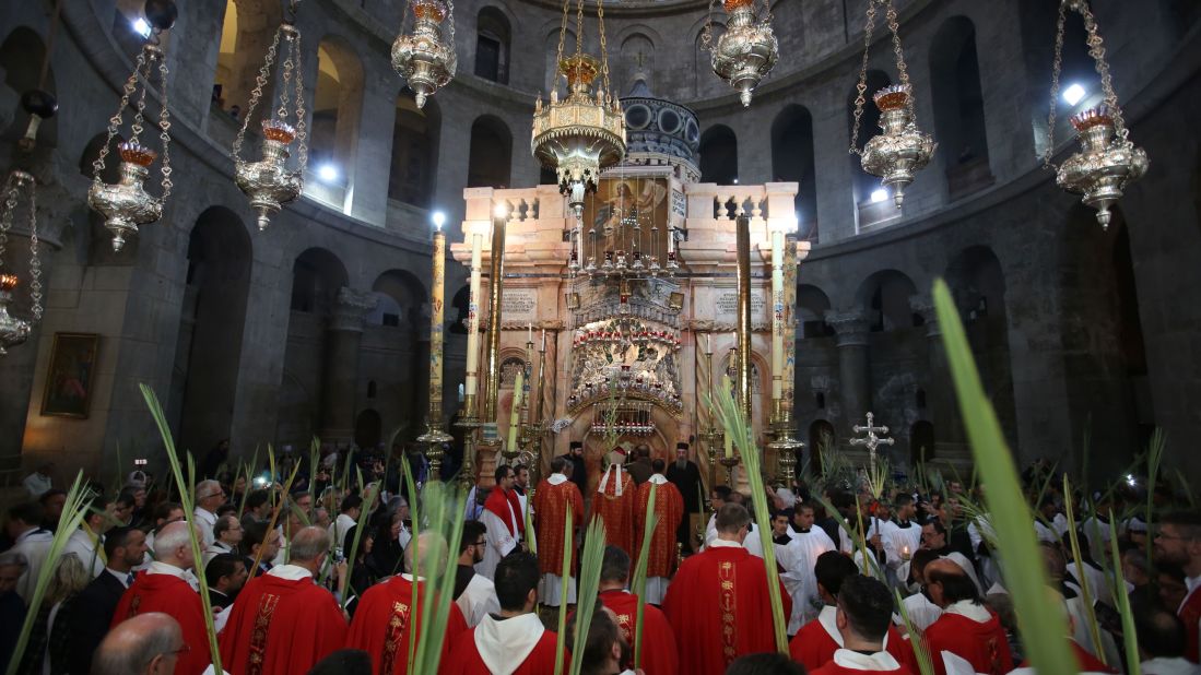 Catholic priests hold palm branches at the Church of the Holy Sepulchre in Jerusalem on Sunday, April 9.