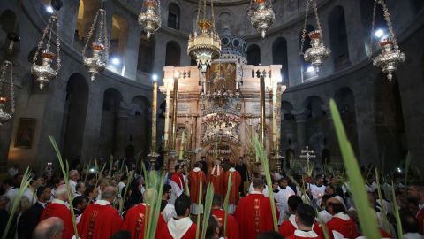 Catholic priests hold palm branches at a Palm Sunday Easter procession. 