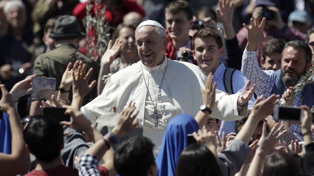 Pope Francis waves to the crowd at the Palm Sunday Mass.