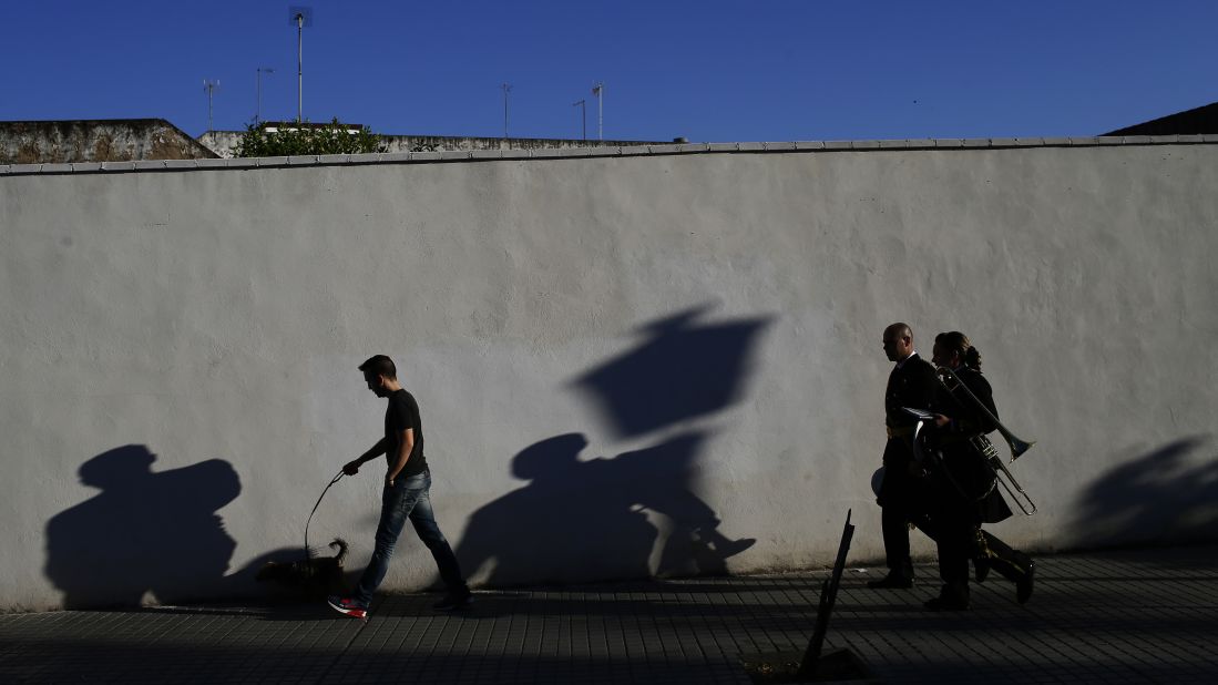 Musicians, right, walk to a church before a Holy Week procession in Cordoba, Spain, on April 9.