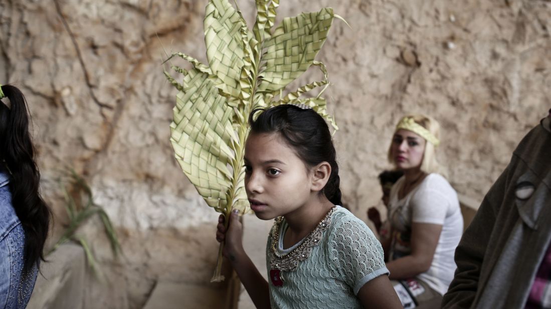A girl holds a palm frond during a Palm Sunday Mass in Cairo.