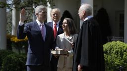 President Donald Trump watches as Supreme Court Justice Anthony Kennedy administers the judicial oath to Neil Gorsuch during a re-enactment in the Rose Garden of the White House on April 10, 2017. Holding the bible is Gorsuch's wife Marie Louise Gorsuch.