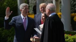 US President Donald Trump watches as Justice Anthony Kennedy(R) administers the oath of office to Neil Gorsuch as an associate justice of the US Supreme Court in the Rose Garden of the White House on April 10, 2017 in Washington, DC as Louise Gorsuch looks on.