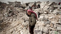 A Syrian man reacts while standing on the rubble of his house while others look for survivors and bodies in the Tariq al-Bab district of the northern city of Aleppo on February 23, 2013. Three surface-to-surface missiles fired by Syrian regime forces in Aleppo's Tariq al-Bab district have left 58 people dead, among them 36 children, the Syrian Observatory for Human Rights said on February 24. AFP PHOTO/PABLO TOSCO        (Photo credit should read Pablo Tosco/AFP/Getty Images)