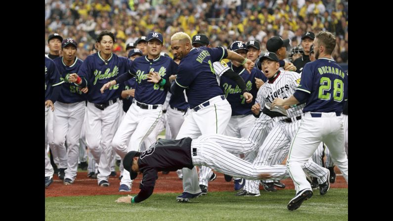 Yakult outfielder Wladimir Balentien shoves over Hanshin coach Akihiro Yano during a bench-clearing scuffle in Osaka, Japan, on Tuesday, April 4. Both were ejected.