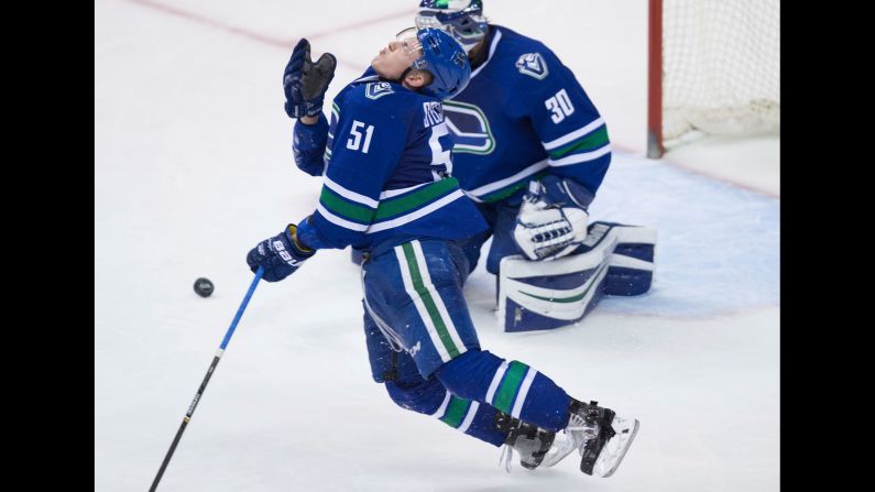 Vancouver's Troy Stecher reacts after getting hit in the face by a puck during an NHL game on Saturday, April 8.