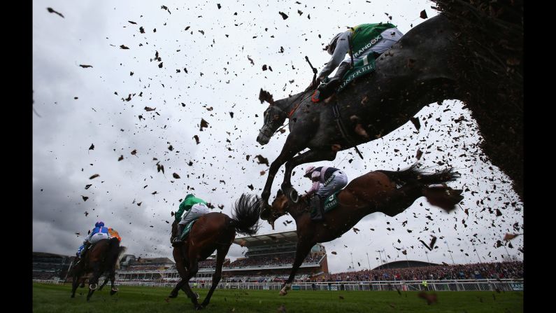 Horses clear a fence during a steeplechase in Liverpool, England, on Thursday, April 6.