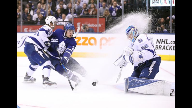 Toronto center Auston Matthews sprays Tampa Bay goalie Andrei Vasilevskiy as he tries to redirect a shot near the net on Thursday, April 6.