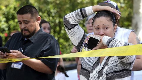 Parents and family of North Park Elementary School students stand across the street from the school waiting to hear from their children after a fatal shooting.