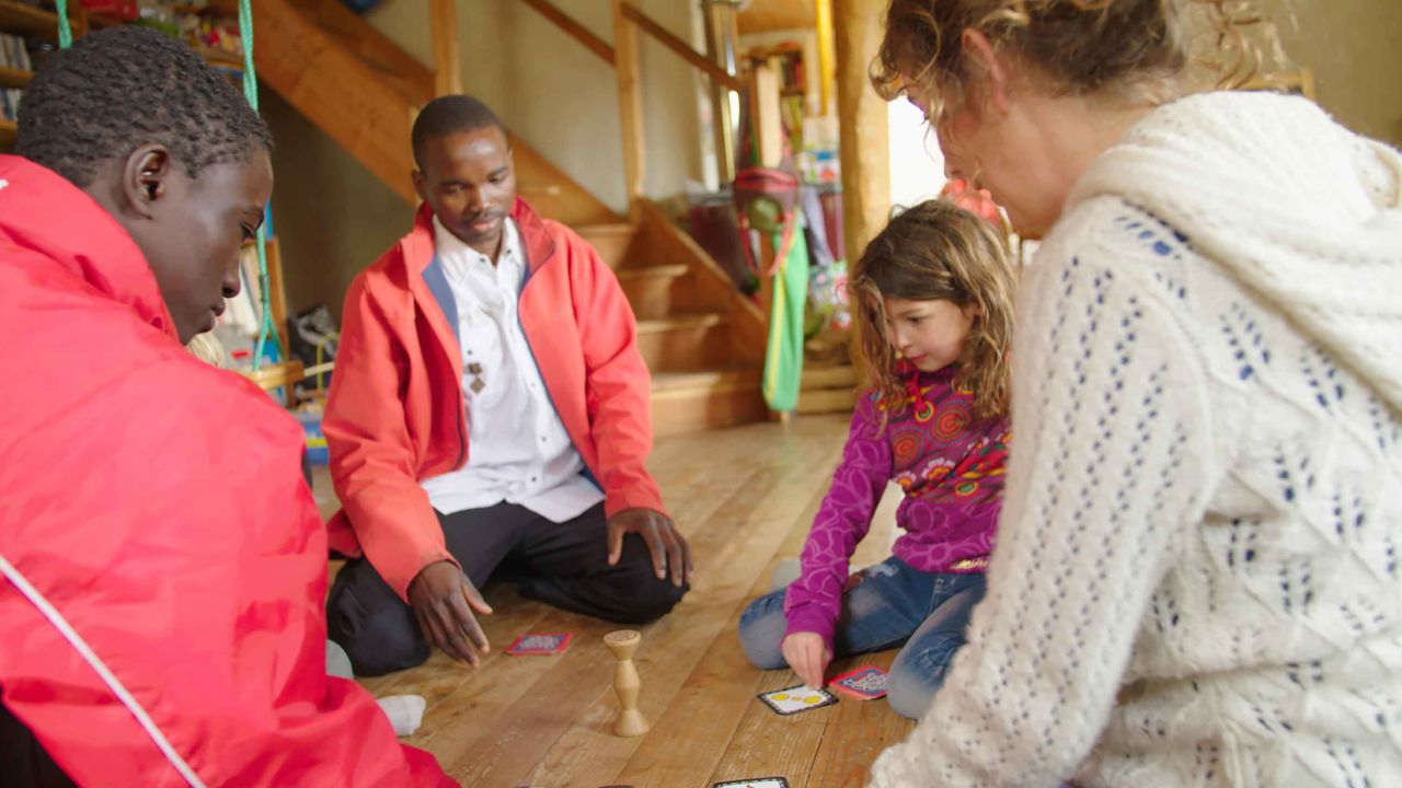 Camille Creton (right) and her children play a game with Yassir, 22, and Amir, 17.
