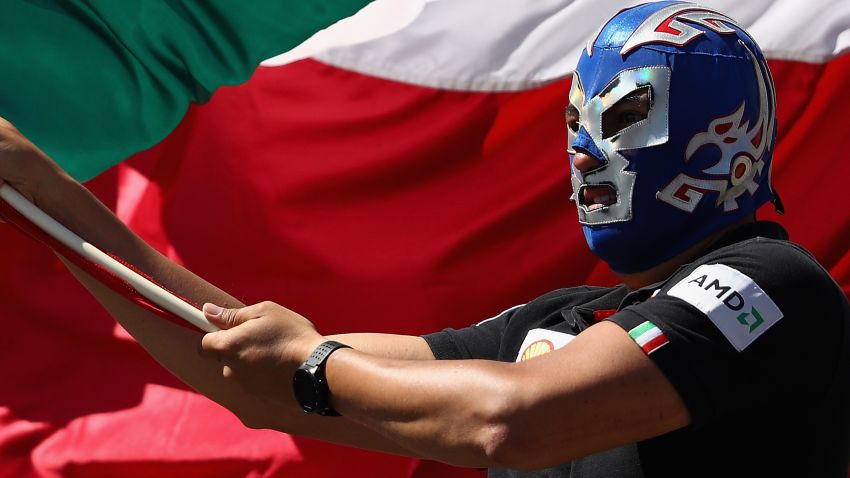An F1 fan waves a Mexican flag while wearing a lucha libre mask