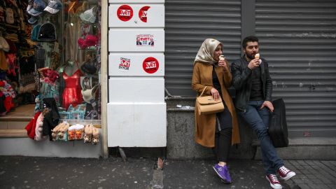 A couple in Istanbul's city center on Sunday, April 9, perch on a street adorned with stickers that say "Evet" -- the symbol for the "Yes" campaign.