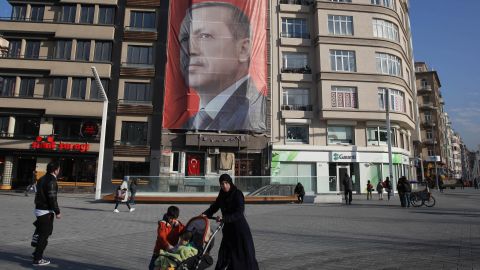 Istanbul residents walk past Erdogan's "Yes" campaign banner in Istanbul's Taksim Square on Sunday.