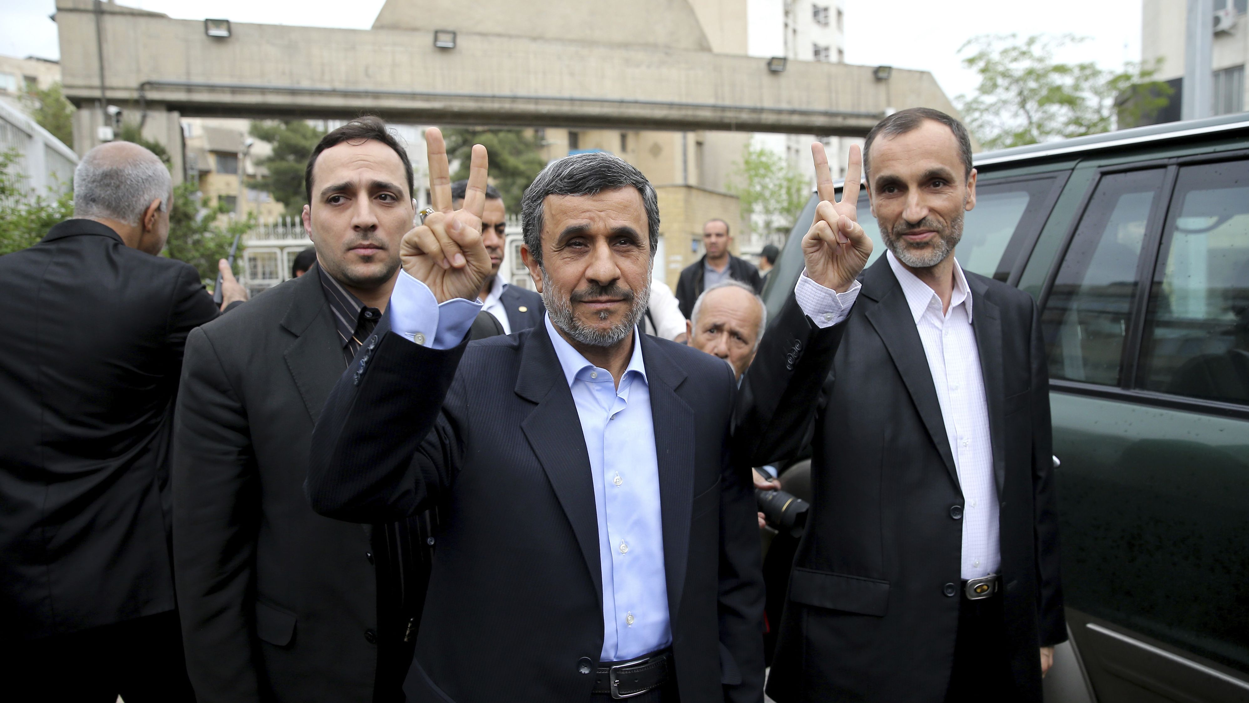 Former Iranian President Mahmoud Ahmadinejad, center, and his close ally Hamid Baghaei flash the victory sign as they arrive at the Interior Ministry to register their candidacy on Wednesday.