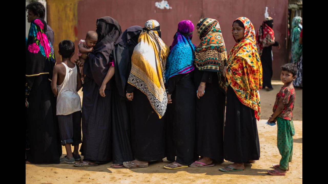 Families wait in line to receive new tarpaulins from the Bangladesh Red Crescent Society in the makeshift extension to Kutupalong camp.