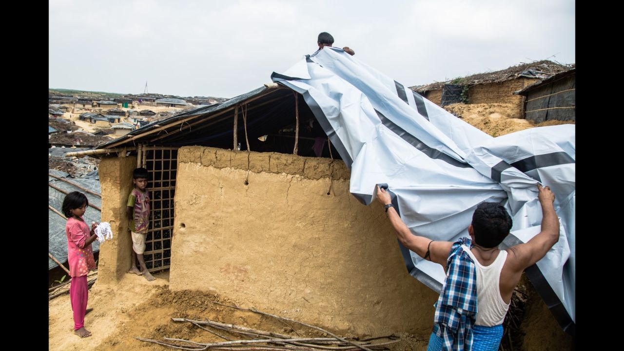 A family installing their new tarpaulin received from the Bangladesh Red Crescent Society (BDRCS) in the makeshift extension to Kutupalong camp.
