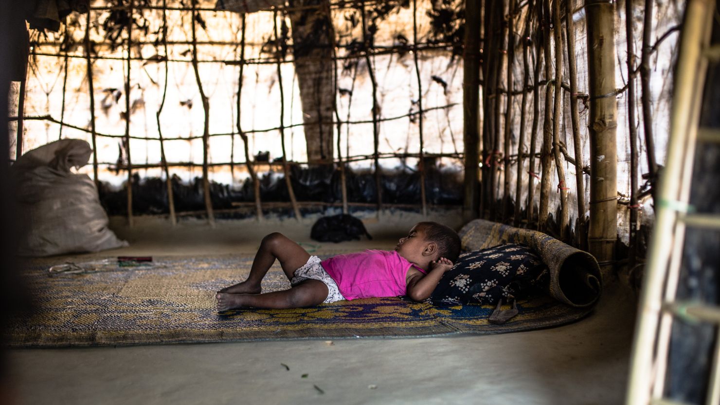 Rabeya's two-year-old daughter sleeps inside their temporary shelter in the makeshift Balukhali camp in Ukhiya, Cox's Bazar district, in south eastern Bangladesh, April 8, 2017. Since October 2016, almost 75,000 people fleeing violence in the northern area of Rakhine State in neighboring Myanmar have arrived in Bangladesh. Many are living in unplanned and overcrowded settlements in the district of Cox's Bazar where living conditions are extremely poor. On 20 March 2017, the International Federation of Red Cross and Red Crescent Societies (IFRC) launched a $3.2 million emergency appeal in support of the Bangladesh Red Crescent Society's efforts to address the most urgent humanitarian needs of the newly arrived migrants. The appeal seeks to ensure that 25,000 of the new arrivals will receive food aid and other emergency relief items, including shelter materials, together with clean water, sanitation, psychosocial support and health care over a nine-month period. Photo: Mirva Helenius / IFRC
