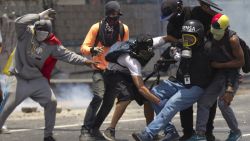Demonstrators help a journalist who was injured in a leg while covering clashes between demonstrators and the  Bolivarian National Guard during a protest in Caracas, Venezuela, Monday, April 10, 2017. Opponents of President Nicolas Maduro protested on the streets of the capital as part of an ongoing protest movement that shows little sign of losing steam. 