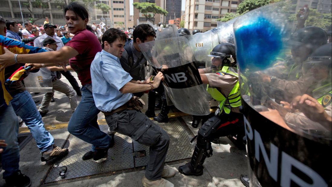 Demonstrators fight with national police officers in Caracas on Tuesday, April 4.