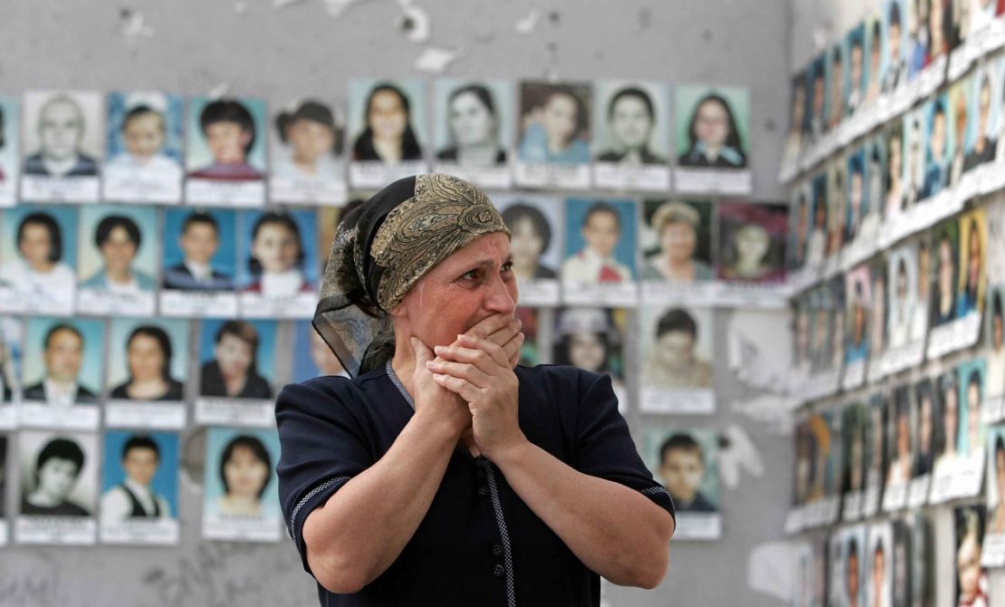 A woman cries as she looks at the pictures of children killed in the school sports hall in Beslan, 30 August 2005. 