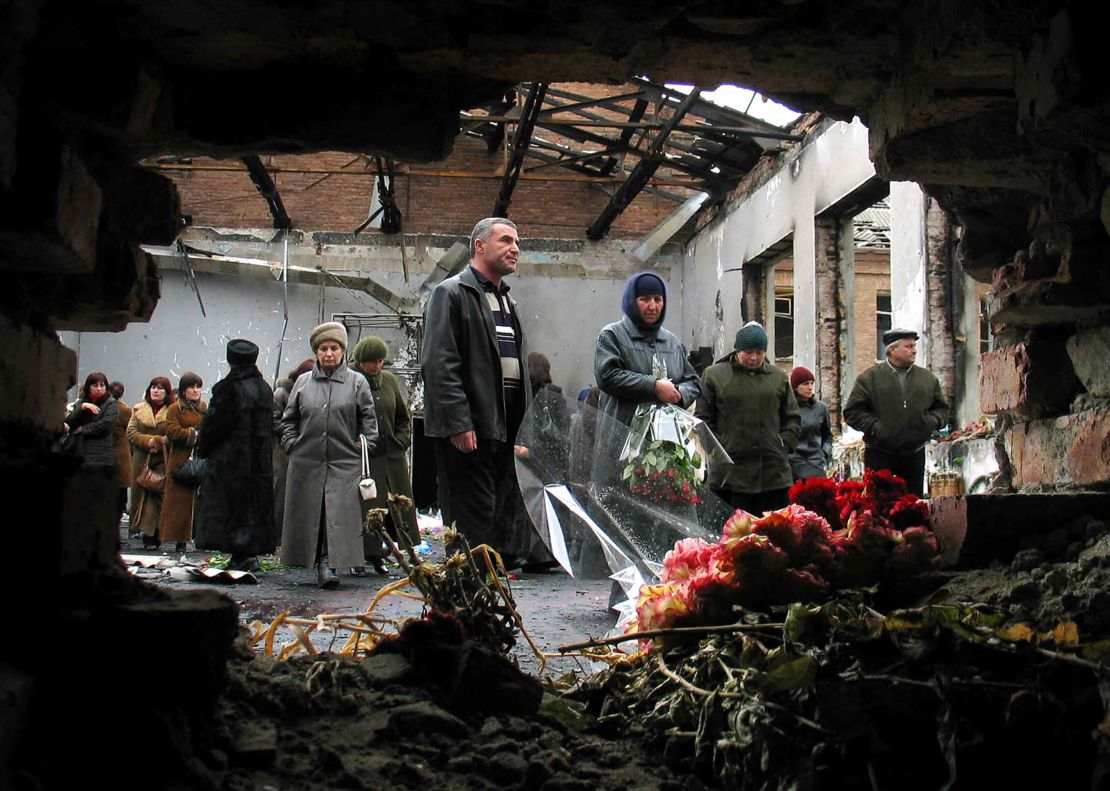 Friends and relatives of those killed hold a minute of silence in the wreckage of the school hall to commemorate the six-month anniversary of the Beslan attack.
