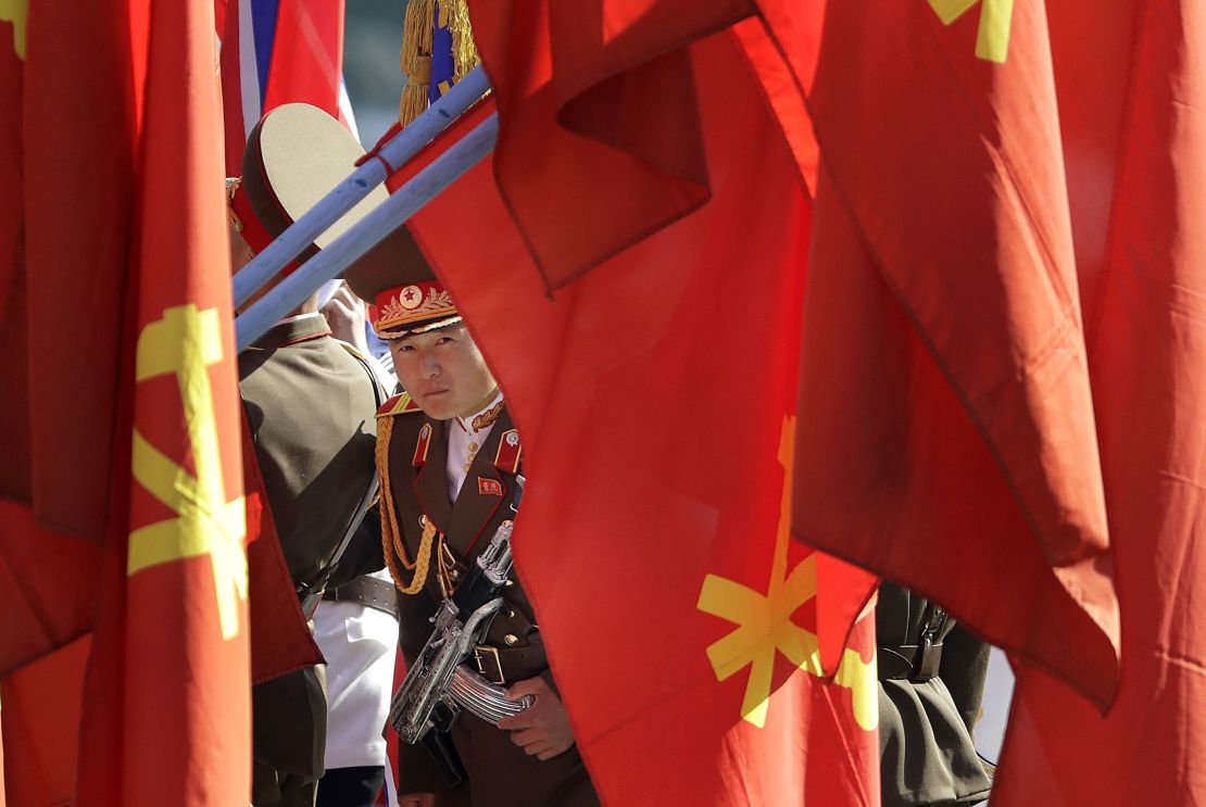 A North Korean soldier peers through flags on display at the Ryomyong residential area.