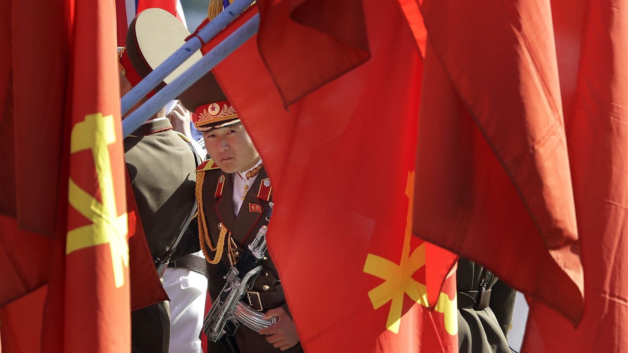 A North Korean soldier peers through flags on display at the Ryomyong residential area.