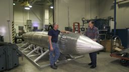 Al Weimorts (left), the creator of the GBU-43/B Massive Ordnance Air Blast bomb, and Joseph Fellenz, lead model maker, look over the prototype of the bomb before it was painted and tested. (Courtesy photo)