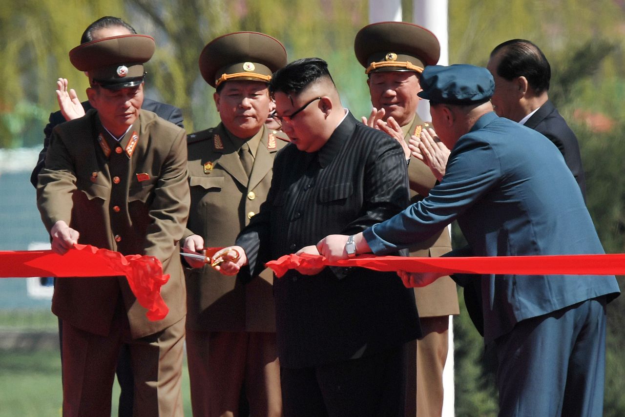 Kim Jong Un cuts a ribbon to mark the opening of the street.