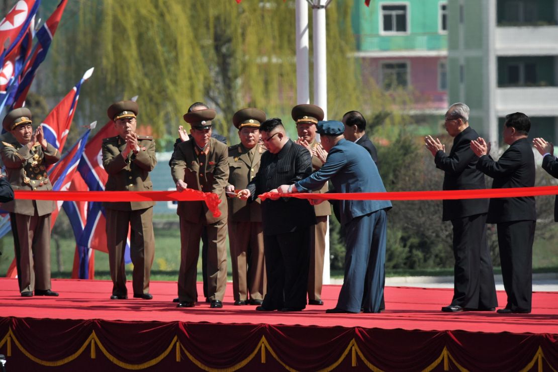 North Korean leader Kim Jong Un cuts the red ribbon during the official opening of the Ryomyong Street housing project.