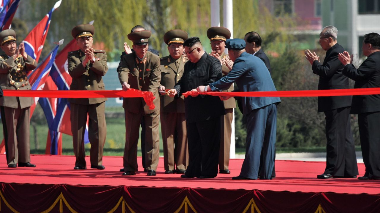 North Korean leader Kim Jong Un cuts the red ribbon during the official opening of the Ryomyong Street housing project.