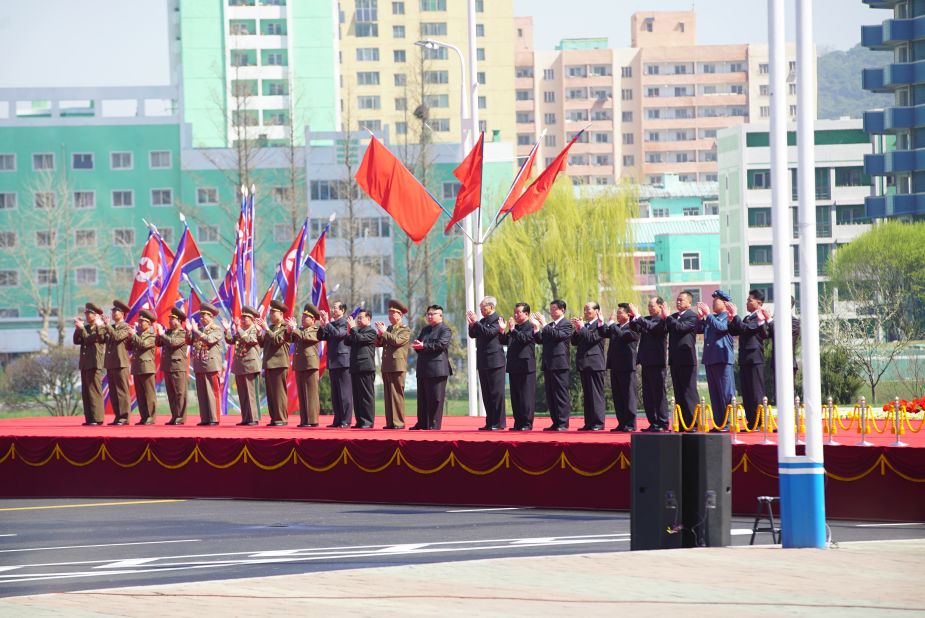 Leaders on stage applaud during at the ceremony.