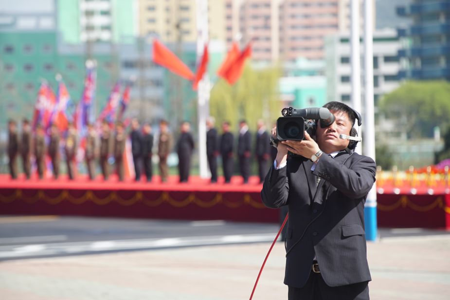 A North Korean cameraman films foreign journalists.