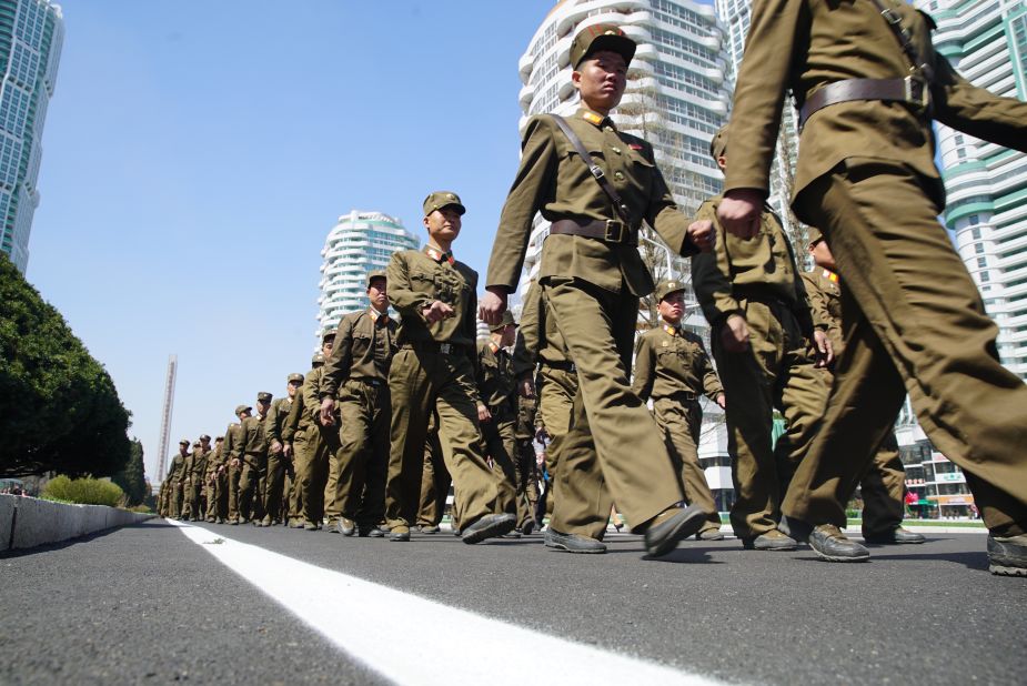 Soldiers march down the street.