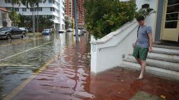MIAMI BEACH, FL - SEPTEMBER 29:  A hotel guest steps out of a hotel into a flooded street that was caused by the combination of the lunar orbit which caused seasonal high tides and what many believe is the rising sea levels due to climate change on September 29, 2015 in Miami Beach, Florida. The City of Miami Beach is in the middle of a five-year, $400 million storm water pump program and other projects that city officials hope will keep the ocean waters from inundating the city as the oceans rise even more in the future.  (Photo by Joe Raedle/Getty Images)