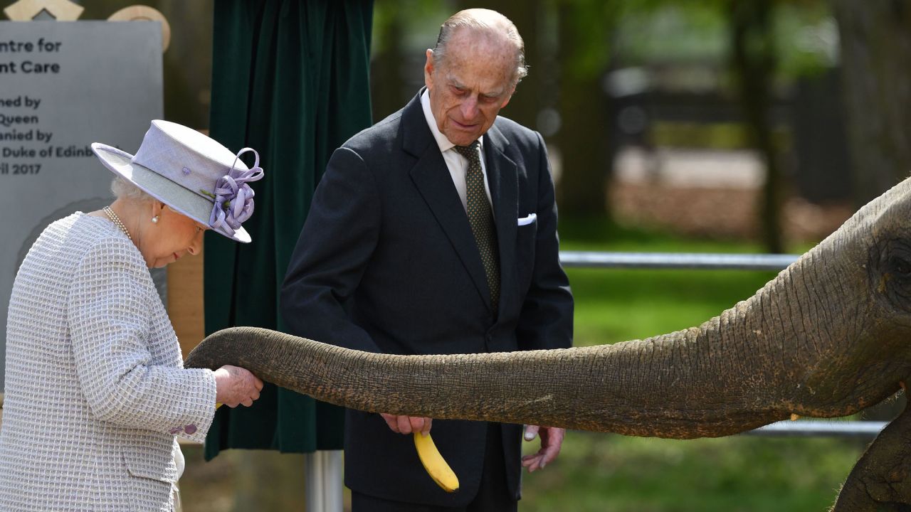Britain's Queen Elizabeth II feeds an elephant at a zoo in Whipsnade, England, as her husband, Prince Philip, watches on Tuesday, April 11. The zoo was opening a new facility for its elephants.