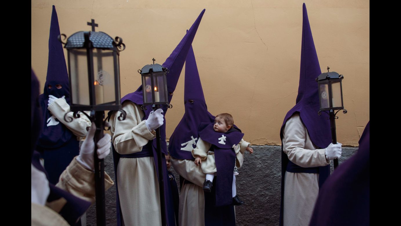 A penitent holds an infant during a Holy Week procession in Zamora, Spain, on Tuesday, April 11.