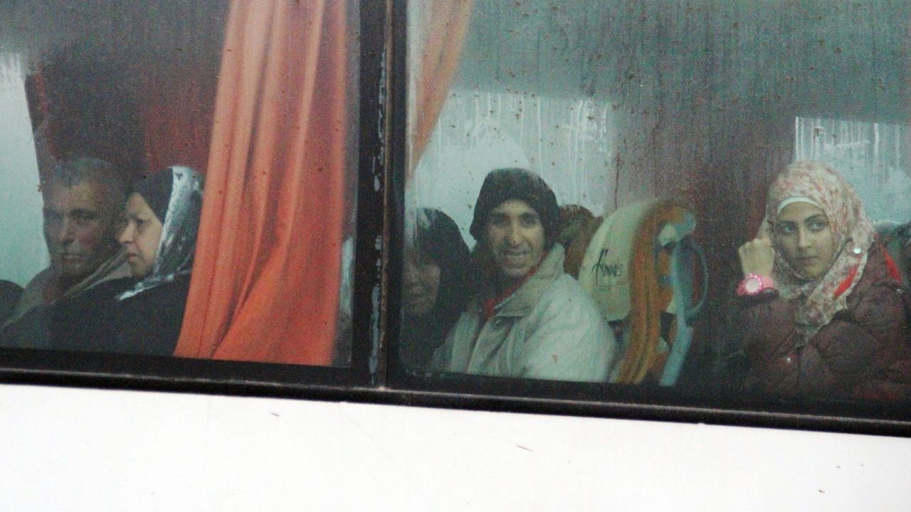 Syrians on a bus from government-held villages make their way through a rebel-held area west of Aleppo.  