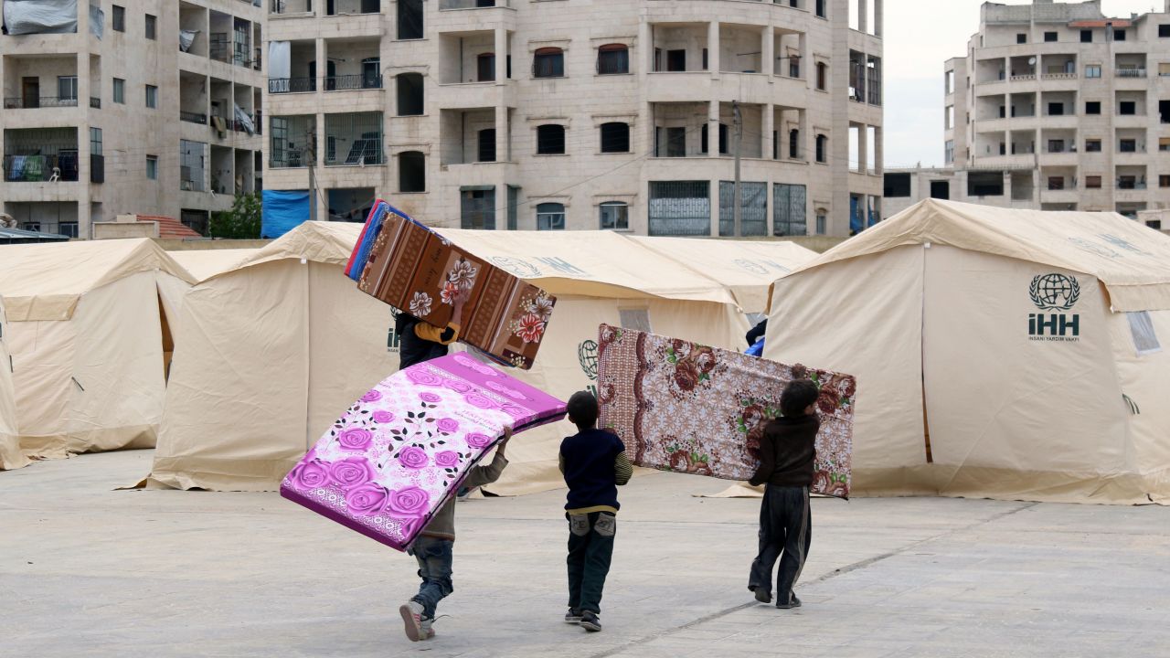 Syrian children prepare mattresses for tents that will house evacuees from Zabadani.