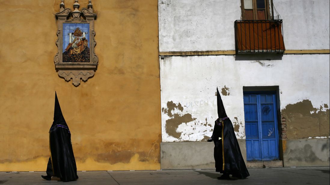 Hooded penitents from the Las Angustias brotherhood take part in a Holy Week procession in Cordoba, Spain, on Thursday, April 13.
